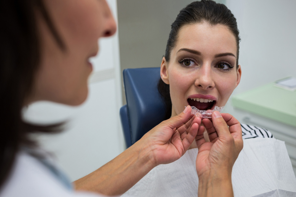 Orthodontiste ajustant un aligneur pour un patient, montrant l'adaptation au traitement orthodontique.